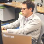 a man sitting in front of a computer monitor