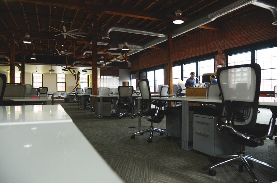 an empty office with people working at their desks