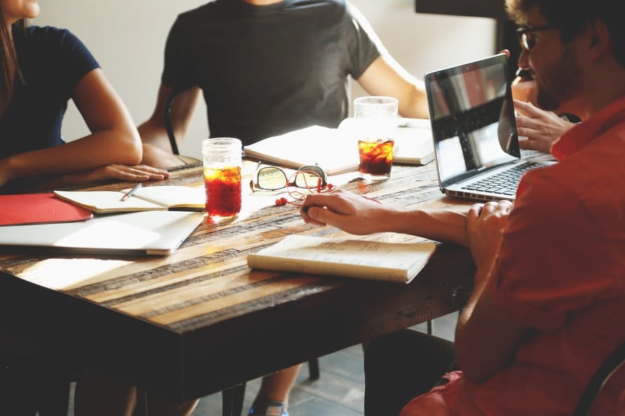 a group of people sitting around a wooden table