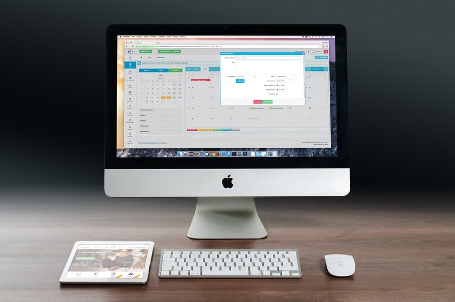 an apple desktop computer sitting on top of a wooden desk