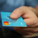 a person holding a credit card in their hand