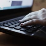 a person typing on a laptop keyboard