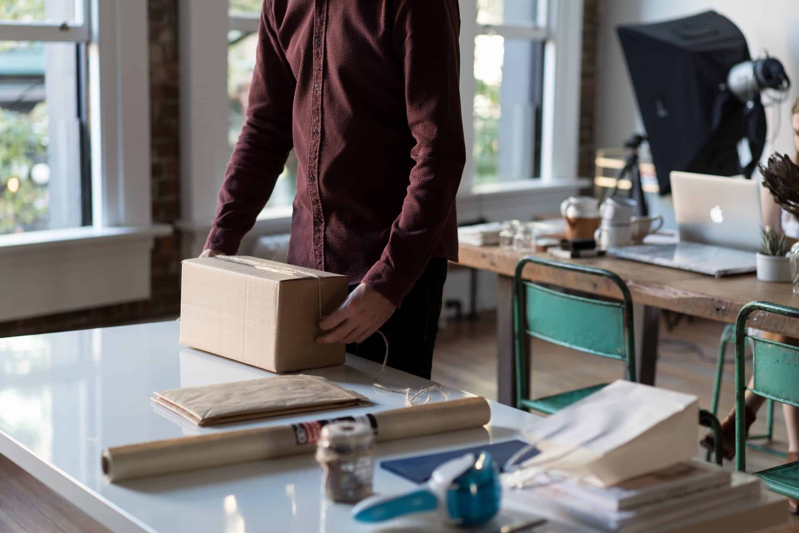 a man standing next to a table with a box on it