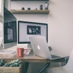 a desk with a laptop and a computer monitor