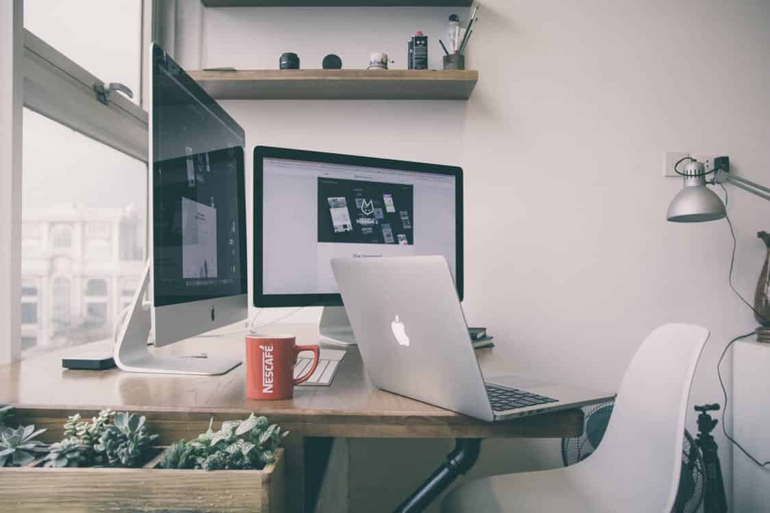 a desk with a laptop and a computer monitor