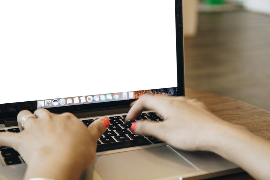 a person typing on a laptop with their hands