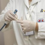 a person in a white lab coat is holding something