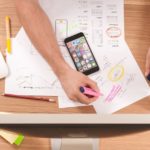 a man is working on some paper with markers and pencils