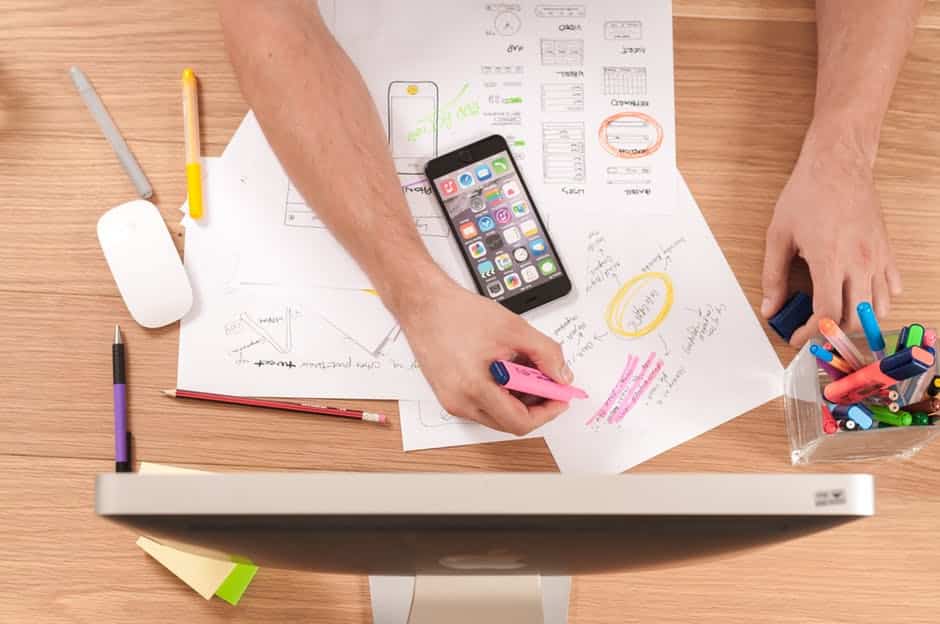 a man is working on some paper with markers and pencils