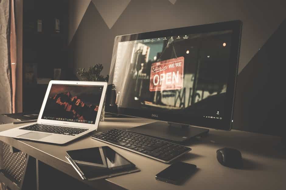 a laptop computer sitting on top of a desk next to a monitor