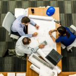 two people sitting at a table working on paperwork