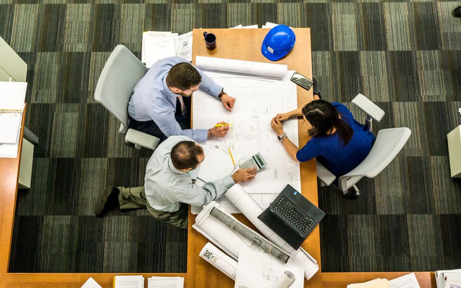 two people sitting at a table working on paperwork