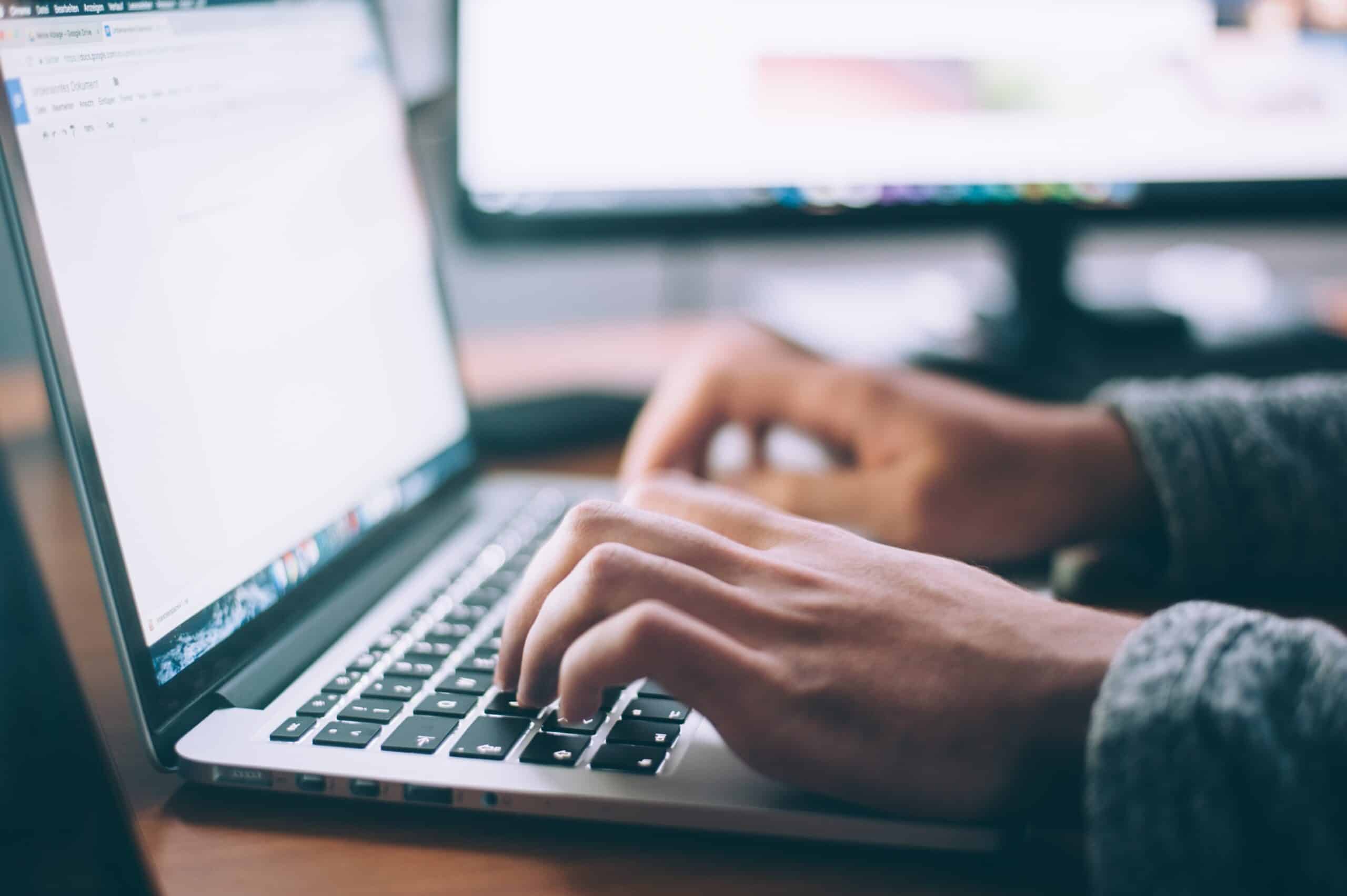 a person typing on a laptop computer