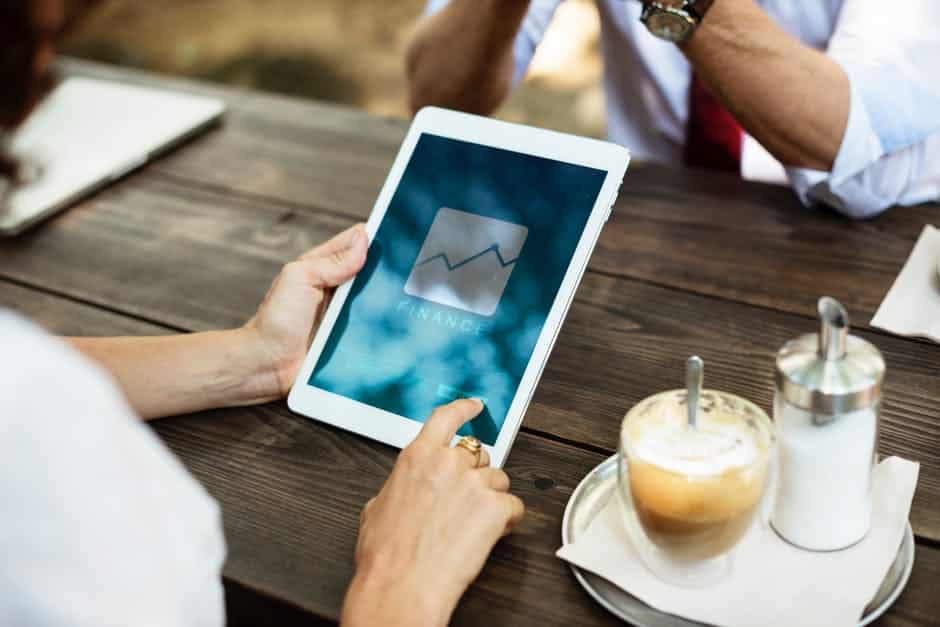 a person sitting at a table with an ipad