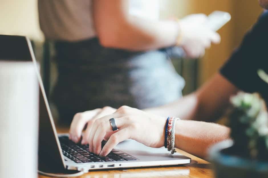 a person typing on a laptop at a table