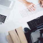 a person typing on a keyboard at a desk