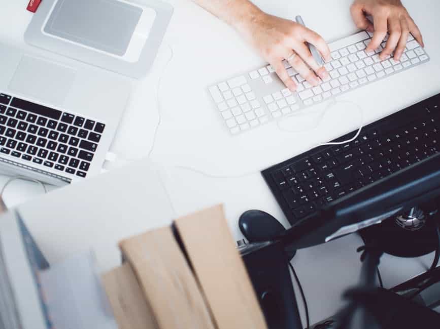 a person typing on a keyboard at a desk