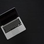 a laptop computer sitting on top of a black table