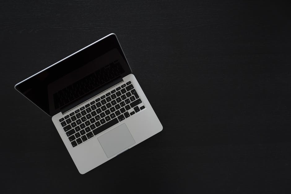 a laptop computer sitting on top of a black table