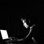 a man sitting in front of a laptop computer