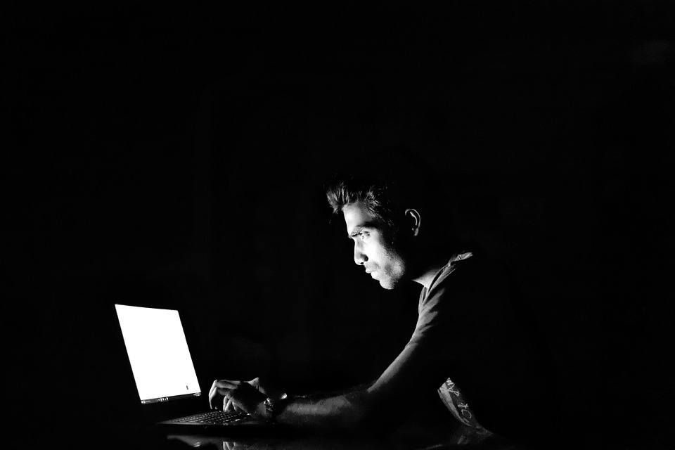 a man sitting in front of a laptop computer