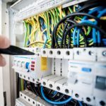 a person is holding a remote control in front of a rack of wires