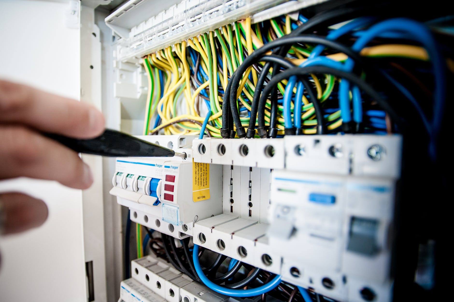 a person is holding a remote control in front of a rack of wires