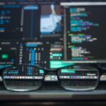 a pair of glasses sitting on top of a laptop computer