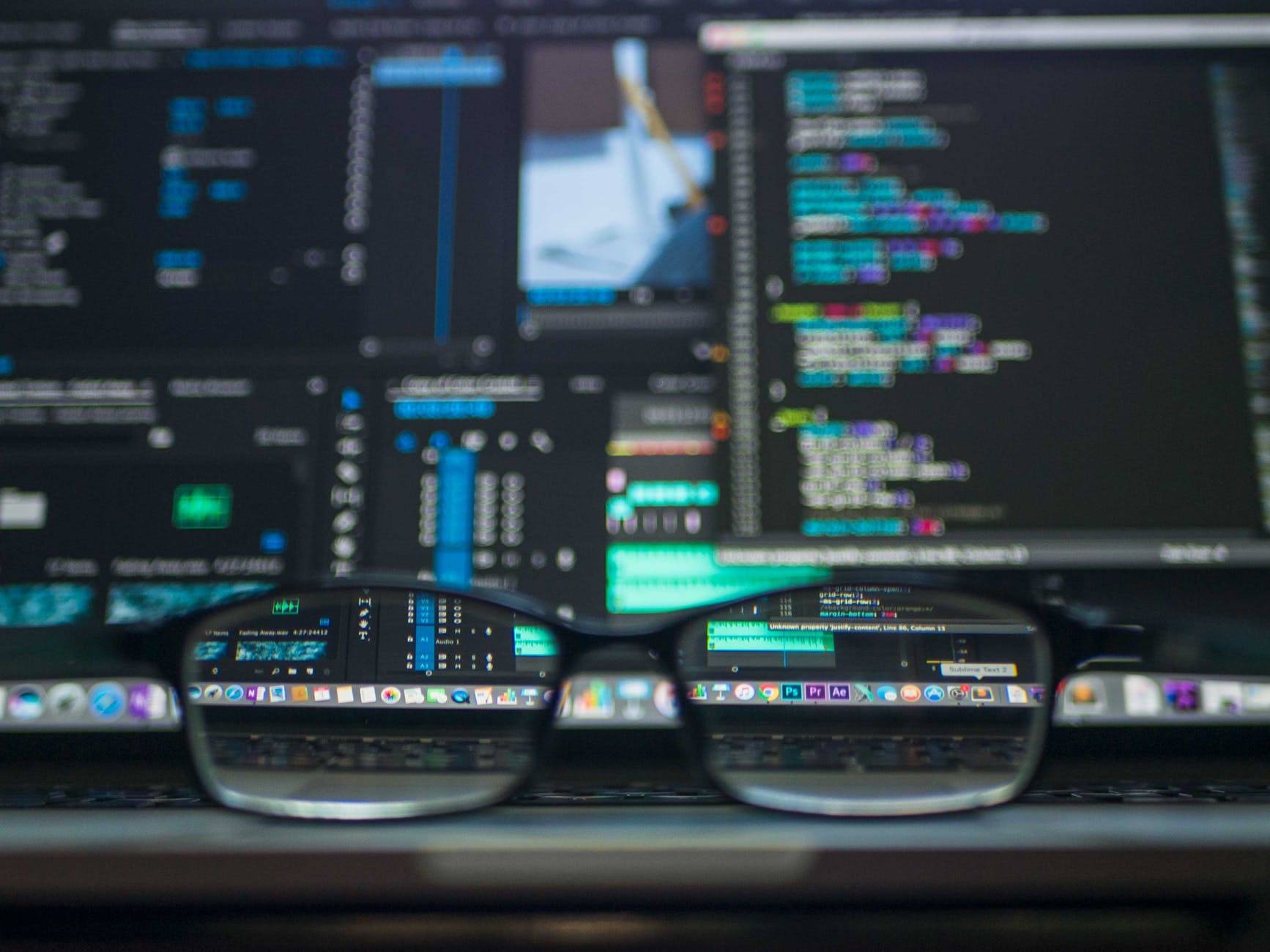 a pair of glasses sitting on top of a laptop computer