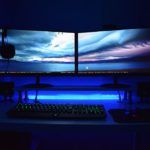 a computer desk topped with two monitors and a keyboard