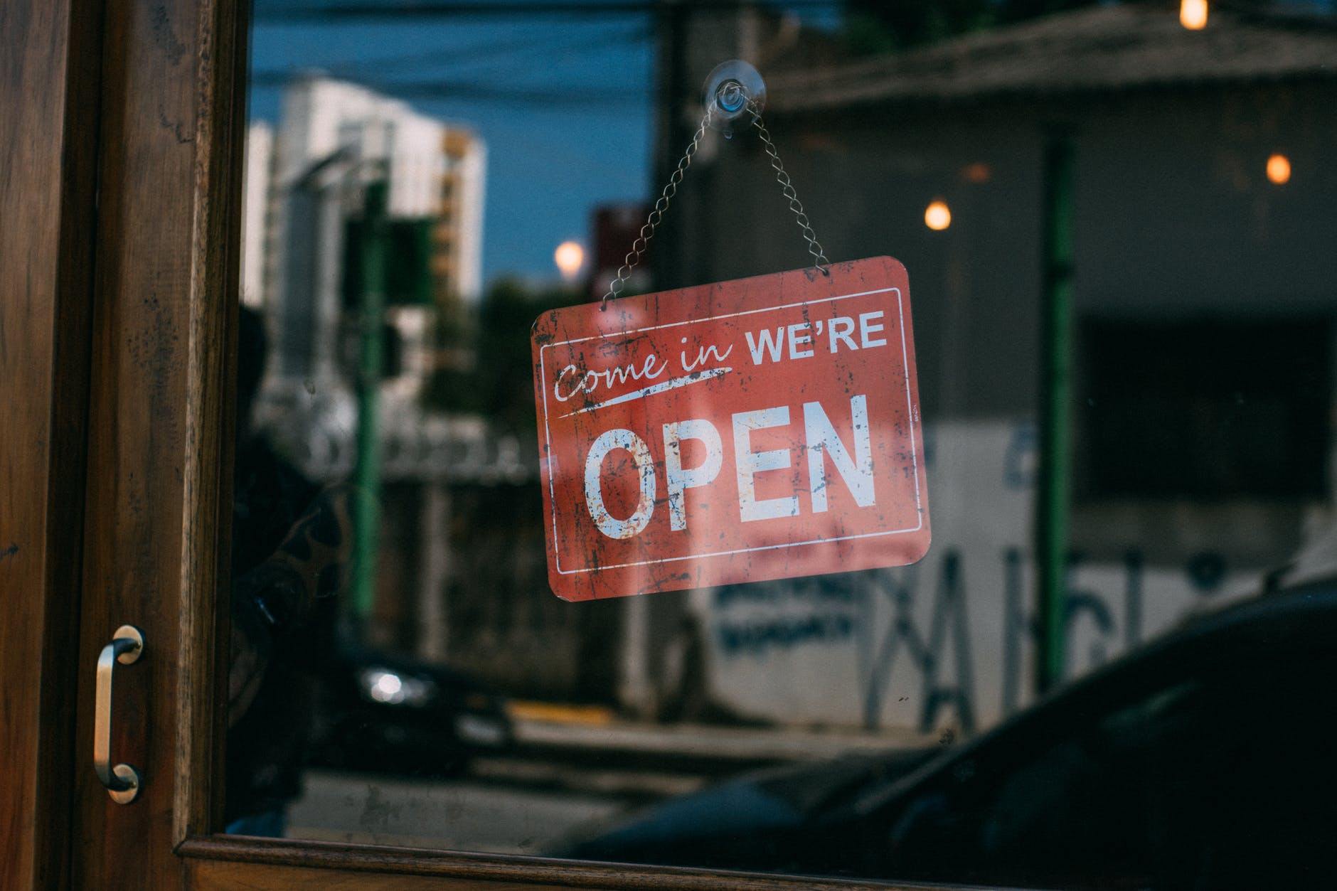 a red sign hanging from the side of a window