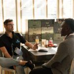 two people sitting at a table talking to each other