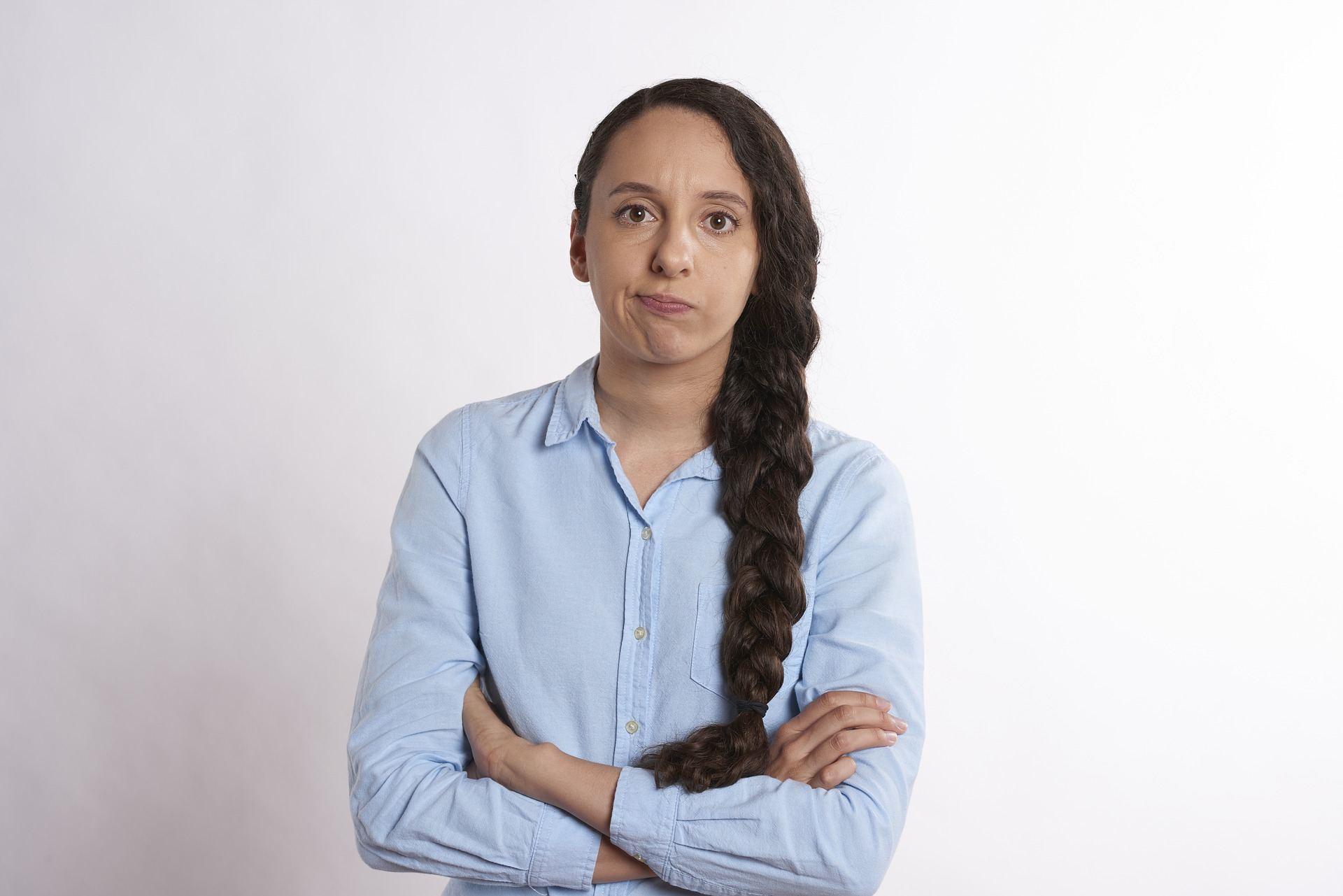 a woman with long hair standing with her arms crossed