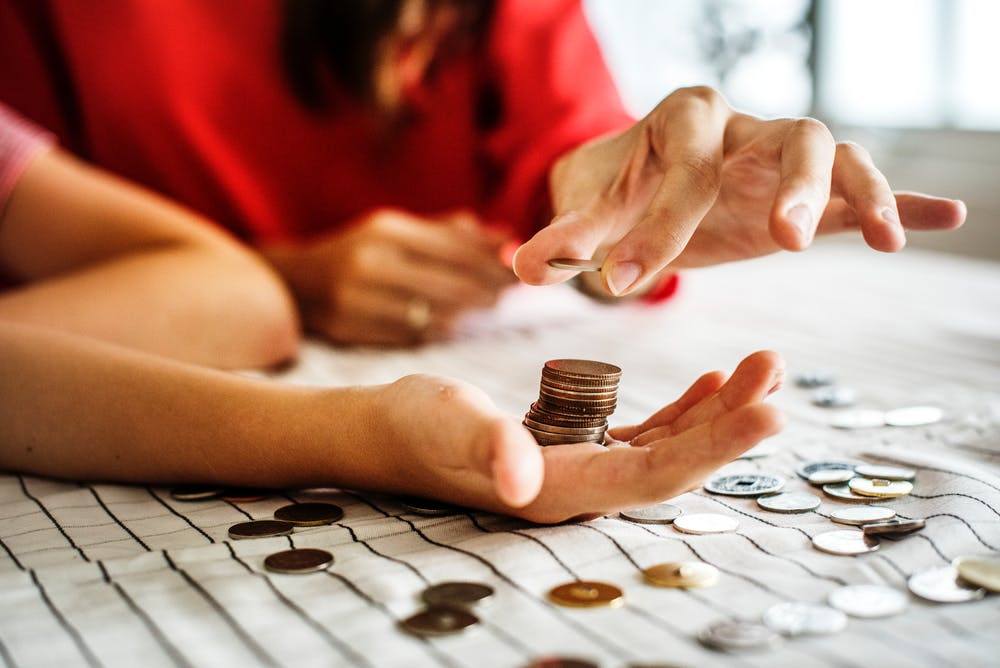 a woman stacking coins on top of a table