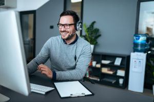 a man wearing headphones sitting in front of a computer