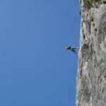 a man hanging from the side of a cliff