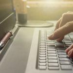 a person typing on a laptop keyboard