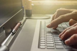 a person typing on a laptop keyboard