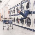 a man hanging from the side of a washing machine