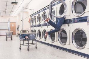 a man hanging from the side of a washing machine