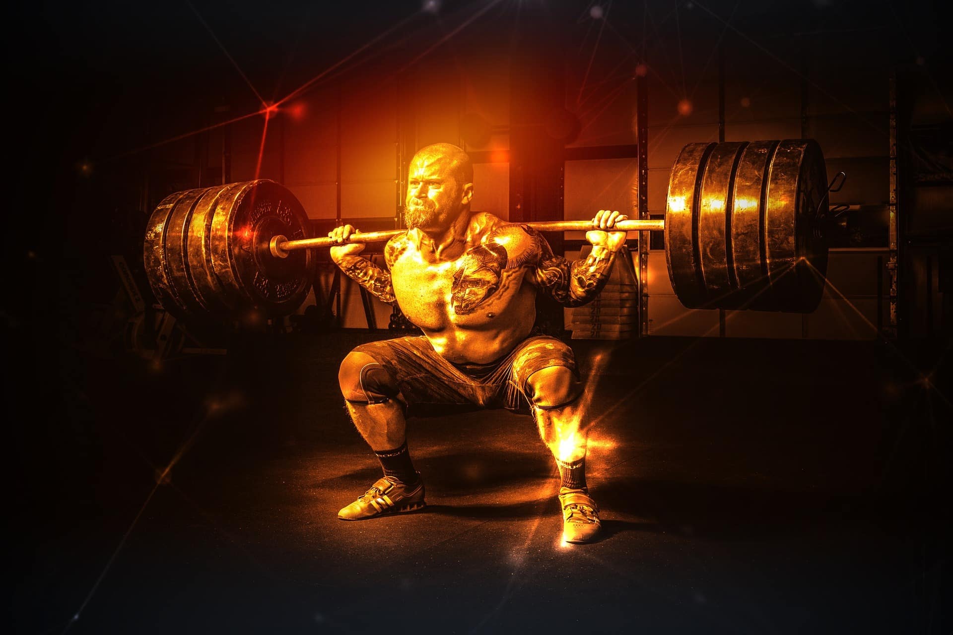 a man squatting down while holding a barbell