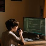 a person sitting at a desk in front of a computer