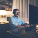 a man wearing headphones and using a laptop