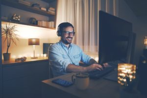 a man wearing headphones and using a laptop