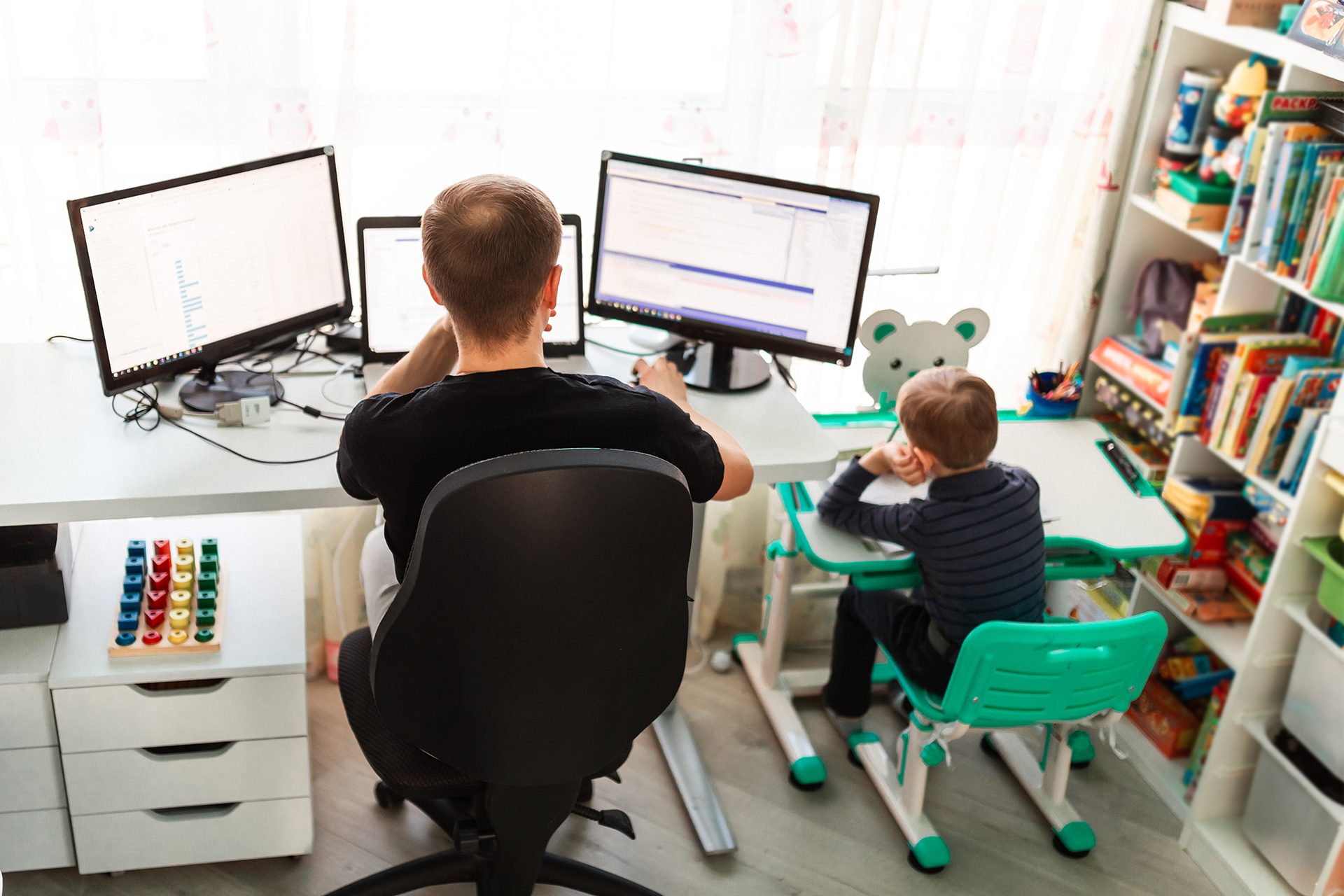 two children sitting at desks in front of computer monitors