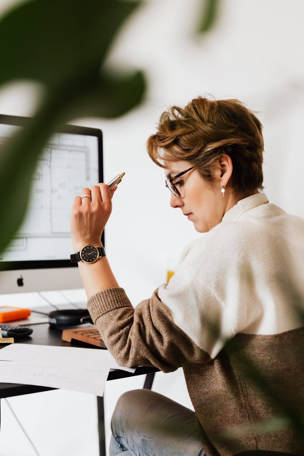 a woman sitting at a desk writing on a piece of paper