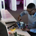 a man is working on a project in front of a computer. Remote Work