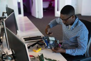 a man is working on a project in front of a computer. Remote Work