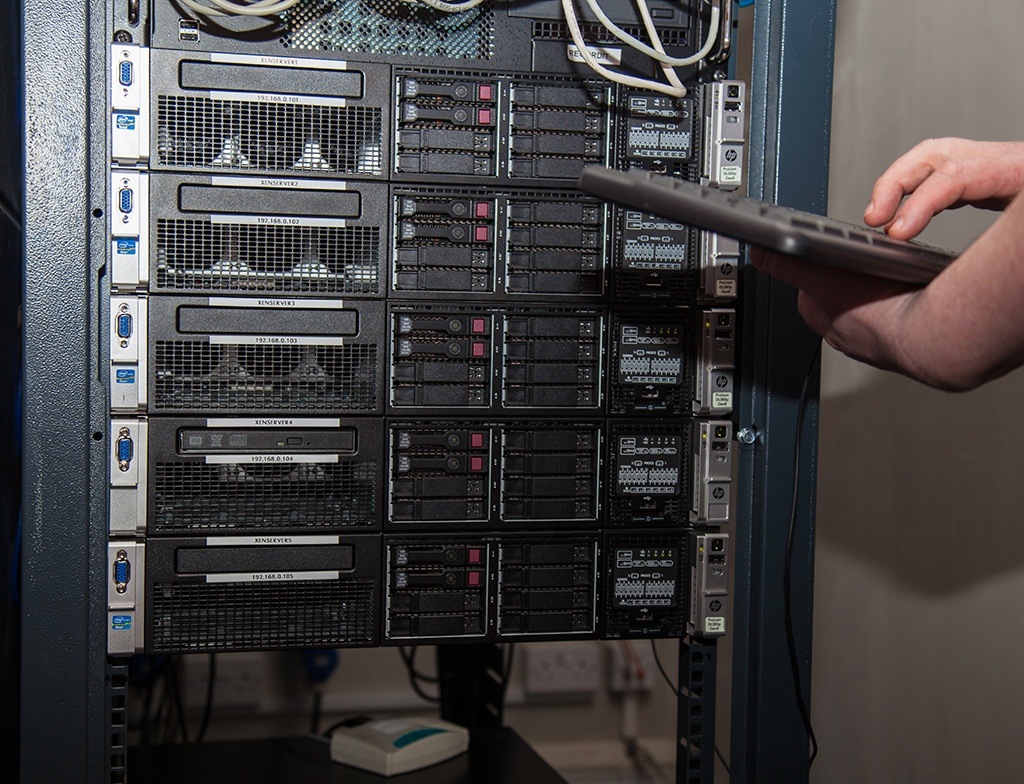 a man is holding a remote control in front of a server