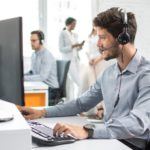 a man sitting at a computer with headphones on